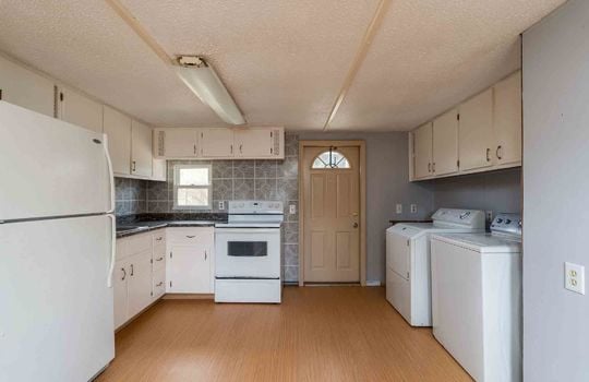 kitchen, refrigerator, stove sink, laundry area, counter top, cabinets, window, exterior door