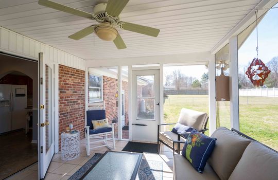 interior view of rear screened porch, ceiling fan, storm door, french doors