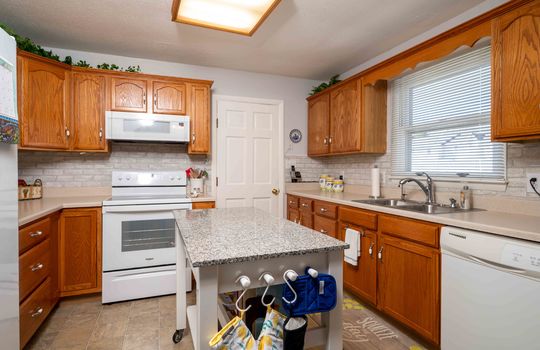 kitchen, window, sink, dishwasher, cabinets, counters, backsplash, oven/stove, door, island