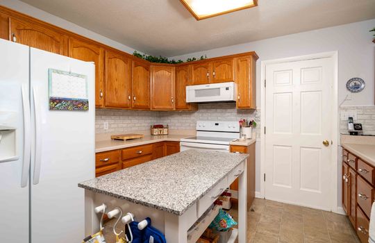 kitchen, refrigerator, counters, cabinets, island, stove, microwave, door