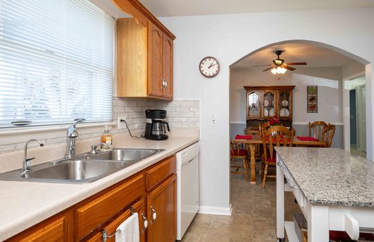 kitchen, sink, window, cabinets, counter top, backsplash, island, arched doorway