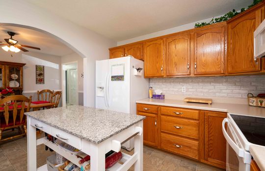 kitchen, refrigerator, island, counter tops, cabinets, stove/oven, microwave, backsplash