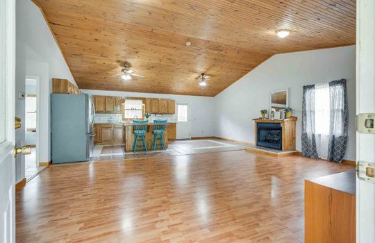 living room, hardwood flooring, vaulted wood ceilings, open floor plan to kitchen