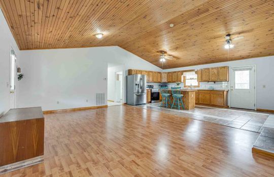 living room, hardwood flooring, vaulted wood ceilings, open floor plan to kitchen