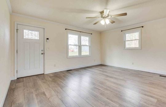 Living room, hallway, vinyl flooring, ceiling fan, windows, front door