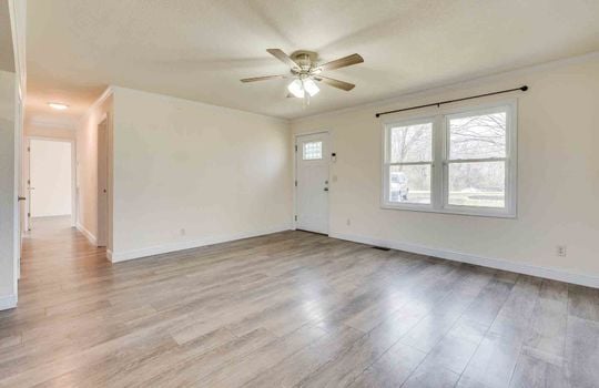 Living room, hallway, vinyl flooring, ceiling fan, windows, front door