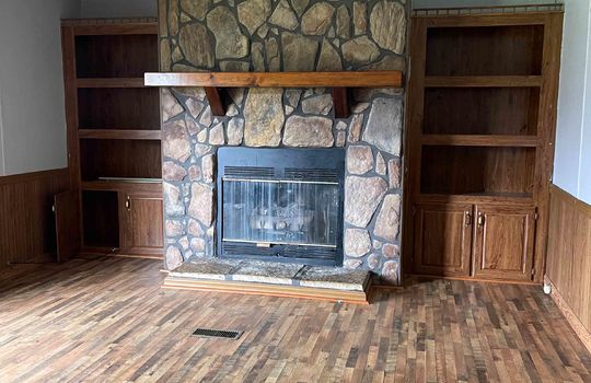 Stone look fireplace, built ins, hardwood flooring