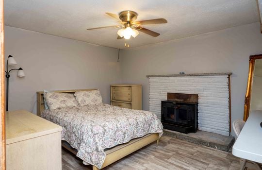 bedroom, ceiling fan, vinyl flooring, fireplace