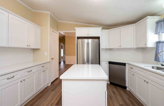 kitchen, refrigerator, dishwasher, kitchen island, cabinets, counters, luxury vinyl flooring