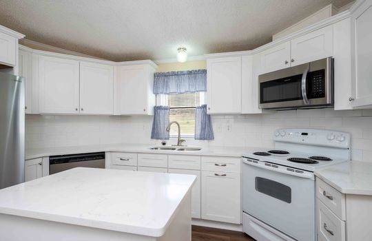 kitchen, white cabinets, island, sink, stove, refrigerator, microwave, dishwasher