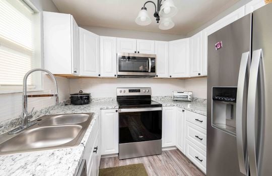 kitchen, white cabinets, stainless appliances, dishwasher, stove, refrigerator, sink, built in microwave, counters