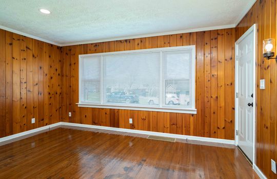 wood panel walls, hardwood flooring, large window