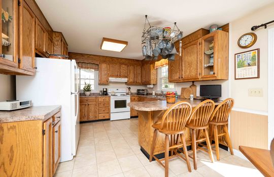 kitchen, pot rack, bar seating, cabinets, window, sink, refrigerator, stove