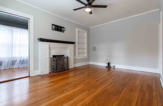 living room, fireplace, built-in shelving, tv mount, hardwood flooring
