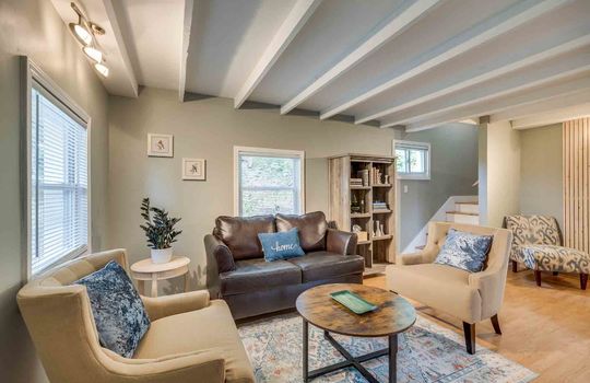 living room, hardwood flooring, ceiling beams, windows