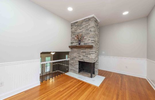 Living room, fireplace, hardwood flooring, recessed lighting