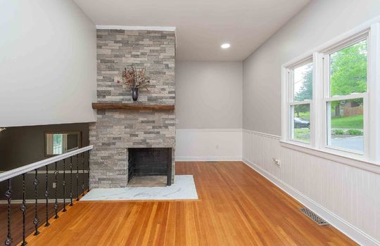Living room, stone fireplace, hardwood flooring, recessed lighting