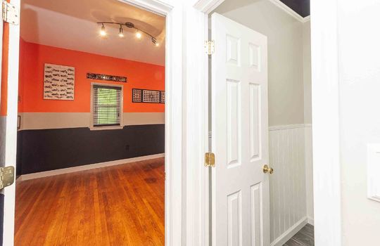 bedroom, hardwood flooring, windows, doorway to bathroom