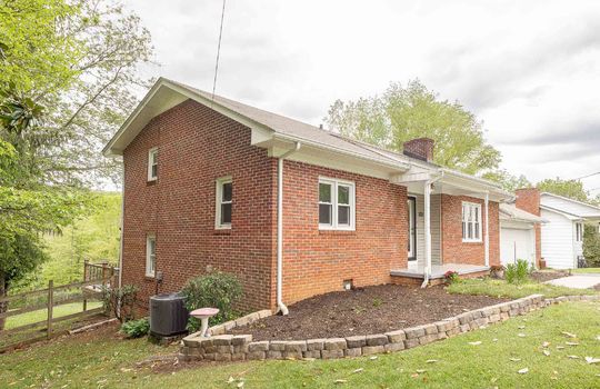 left side view, brick tri-level, yard, front porch, front door, garage, landscaping