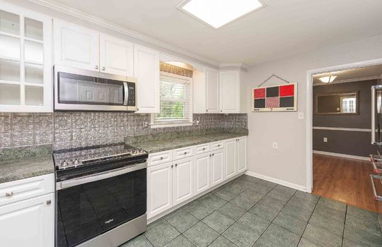 kitchen, tile flooring, stove, microwave, cabinets, window