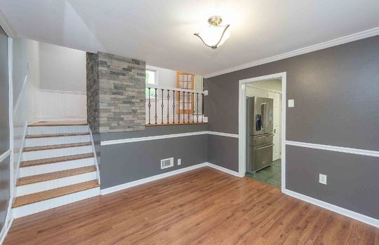 additional lower level living space, wainscoting, stairs, hardwood flooring