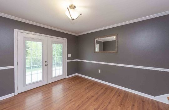 additional lower level living space, wainscoting, french doors, hardwood flooring