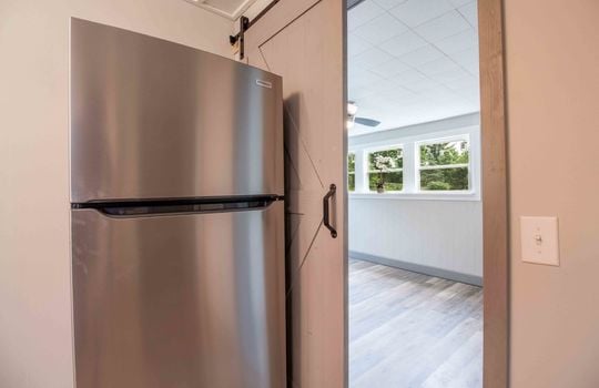 kitchen view into bonus room, refrigerator, vinyl flooring