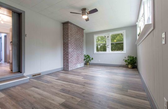 bonus room, exterior entry, vinyl flooring, ceiling fan, windows, brick accent