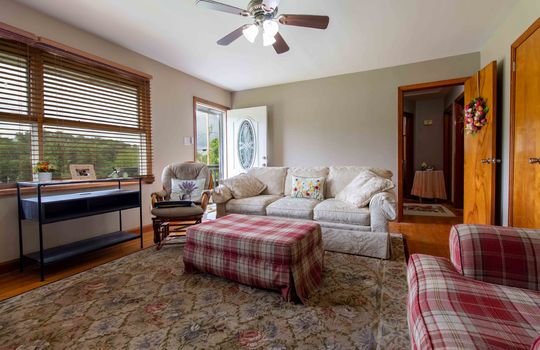 Living room, hardwood flooring, ceiling fan, front door
