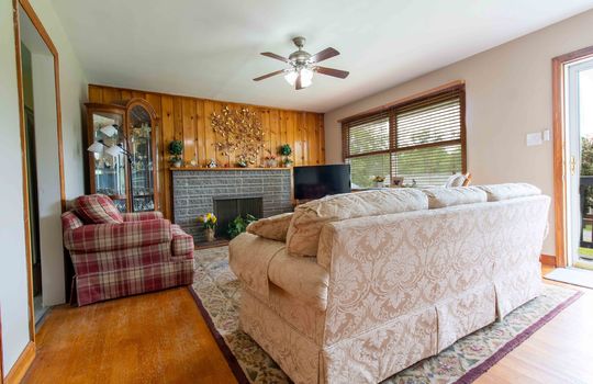 Living room, wood feature wall, ceiling fan, hardwood flooring, wood trim