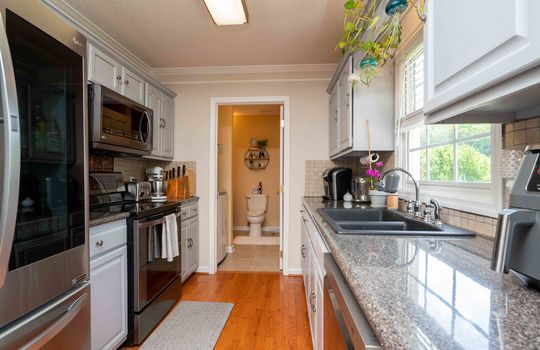 kitchen, cabinets, stove, sink, dishwasher, refrigerator, hardwood flooring, doorway to laundry space
