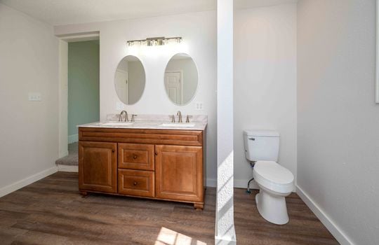 primary bathroom, double sink, toilet, hardwood flooring