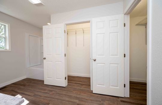 primary bathroom, closet, hardwood flooring, tub/shower