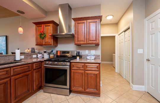 kitchen, tile flooring, sink, cabinets, granite countertops, pantry, view into hallway