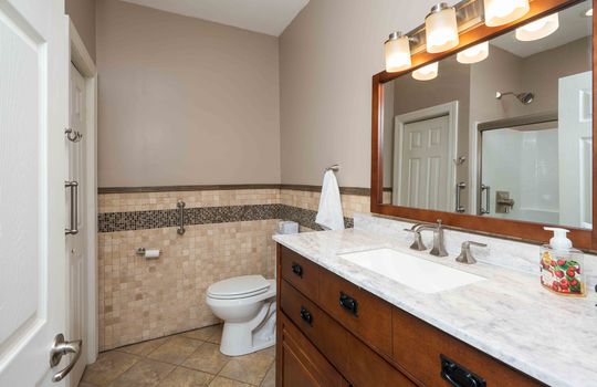 primary bathroom, tile flooring, cabinet, sink, toilet, tile wall