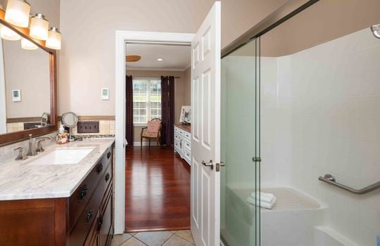 primary bath, tile flooring, shower, glass shower door, sink