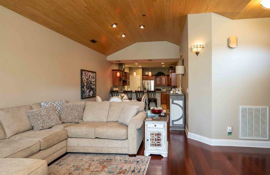 condo, living room, cherry hardwood flooring, arched windows, brick fireplace, wood ceiling, open floor plan, kitchen