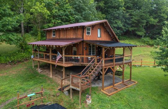 log cabin, deck, covered porch, covered deck, wood stairs, yard, trees