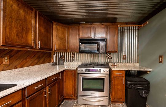 kitchen, cabinets, wood backsplash, metal ceiling, metal backsplash, stove, microwave