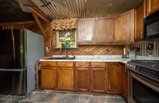 kitchen, metal ceilng, cabinets, wood backsplash, window, sink, refrigerator, stove, microwave