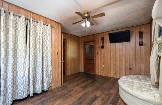 bedroom, closet, door, ceiling fan, paneling walls, laminate flooring