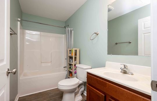 bathroom, laminate flooring, toilet, tub/shower, sink