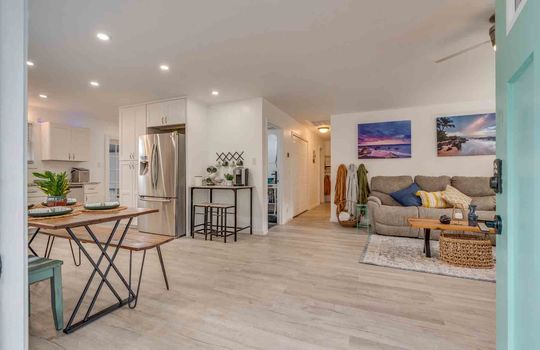 open floorplan living room, dining area, kitchen, hallway view, luxury vinyl flooring