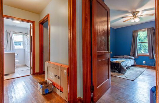 hallway, hardwood flooring, view into bedroom, view into bathroom