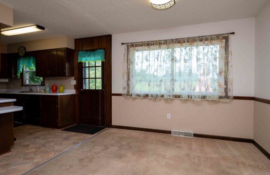 dining area, kitchen, door to back deck, windows, vinyl flooring