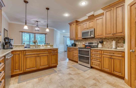 kitchen, luxury vinyl, cabinets, counters, recessed lighting, pendant light, stove, microwave, dishwasher
