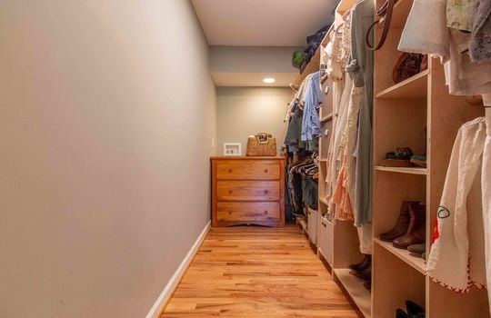 primary bedroom, walk in closet, shelving, storage, hardwood flooring