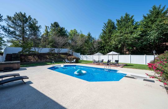 Back yard, in ground pool, landscaping, brick sitting area, hot tub, fencing