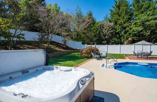 Back yard, hot tub, in-ground pool, brick sitting area, fencing, landscaping, trees, shrubs