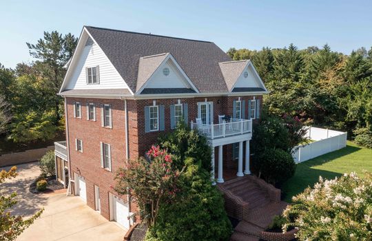 3 story brick traditional home, brick stairs, columns, balcony, fencing, two car garage, landscaping